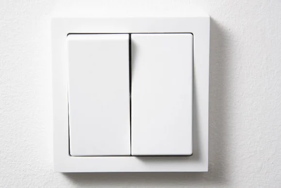 Weißer Lichtschalter mit zwei Schaltern.